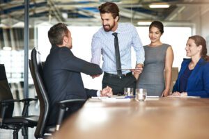 people shaking hands and meeting in the workplace
