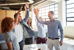 people high fiving and celebrating in the workplace