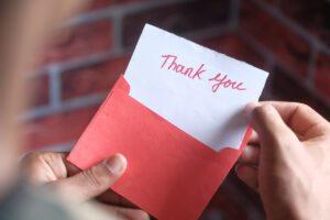 person opening a thank you card