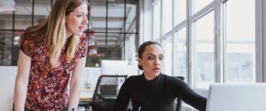person showing coworker something on computer